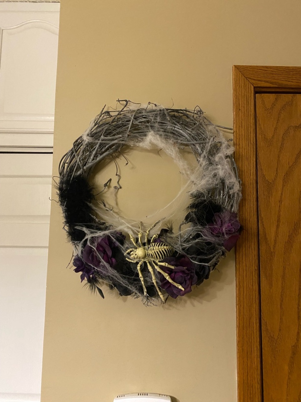 Halloween wreath with spider skeleton, flowers and cobwebs